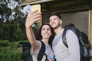 Ein glückliches Paar hält einen gemeinsamen Moment mit einem Selfie mit seinem Smartphone fest - ASGF03931