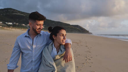 Smiling woman with boyfriend at beach - ASGF03943