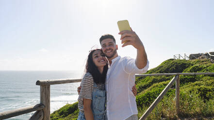 Young couple taking selfie through smart phone - ASGF03957