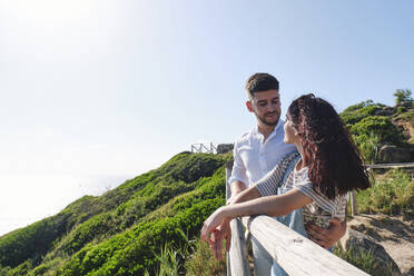 Romantisches Paar steht in der Nähe von Geländer am sonnigen Tag - ASGF03962