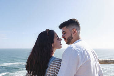 Romantic young couple with face to face in front of sky - ASGF03963