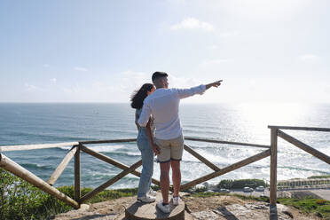 Boyfriend and girlfriend looking at sea - ASGF03977