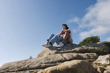 Freund und Freundin sitzen zusammen auf Felsen - ASGF03983