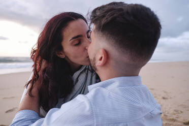 Zärtliches Paar, das sich am Strand küsst - ASGF04014