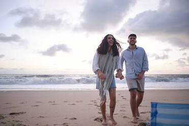 Glückliches junges Paar am Strand stehend - ASGF04020