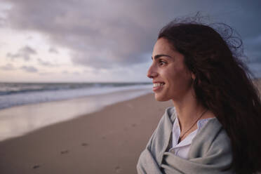 Smiling woman looking at sea - ASGF04026