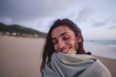 Happy woman with eyes closed at beach - ASGF04031