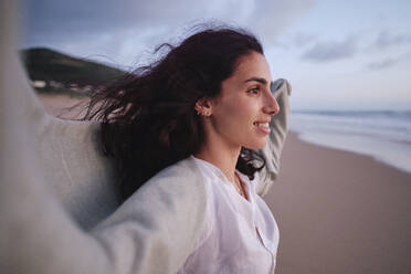 Lächelnde Frau verbringt ihre Freizeit am Strand - ASGF04034
