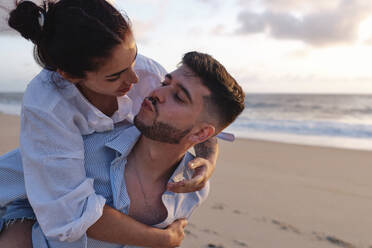 Man puckering to woman enjoying at beach - ASGF04047