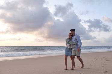 Mann und Frau verbringen ihre Freizeit mit einem Spaziergang im Sand am Strand - ASGF04063