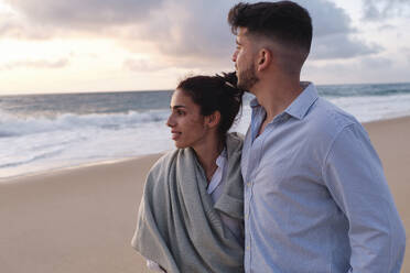 Mann und Frau schauen auf das Meer am Strand - ASGF04067
