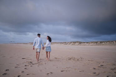 Young woman walking with boyfriend at beach - ASGF04075