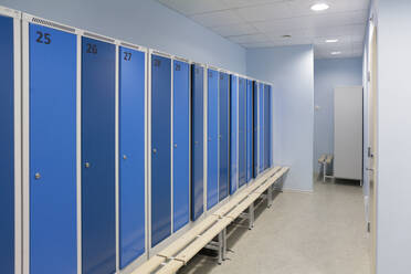 Sports and exercise facilities indoors in a gym, changing rooms, lockers with blue doors. - MINF16635
