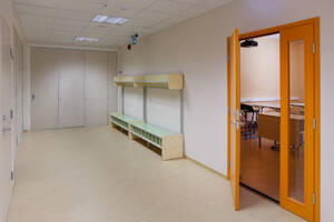 A school corridor and yellow locker room door, bench and coat stand and shoe store. - MINF16640