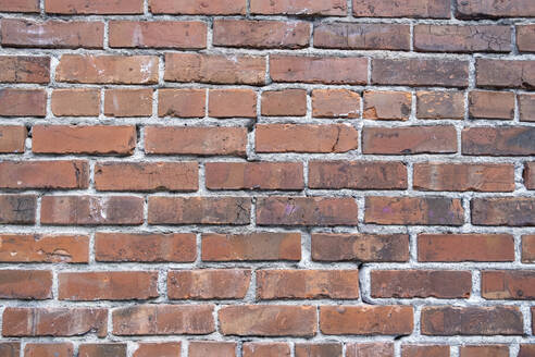 A brick wall, red clay bricks laid in a regular pattern to make a wall. - MINF16652