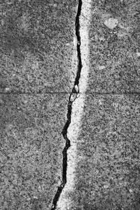 A crack between flagstones painted with a white line, on a concrete sidewalk surface. - MINF16653