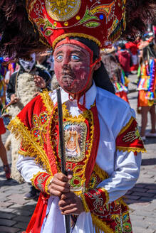Cusco, a cultural fiesta, people dressed in traditional colourful costumes with masks and hats with feathers. - MINF16682