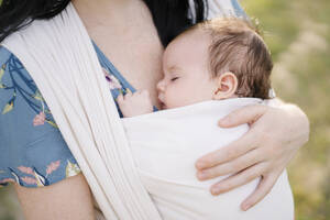 Mutter trägt Tochter schlafend im Tragetuch - SSYF00166
