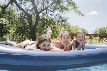 Freunde liegen auf einem Floß im Schwimmbad - OSF01892