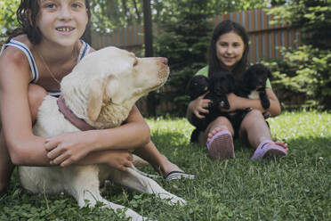 Friends spending leisure time with dogs in back yard - OSF01903