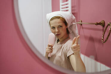 Junge verspielte Frau gestikuliert im Badezimmerspiegel - YBF00022