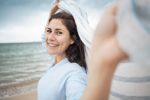 Cheerful woman with scarf at beach - JOSEF19999