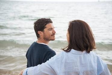 Lächelnder Mann mit Frau vor dem Meer am Strand - JOSEF20057