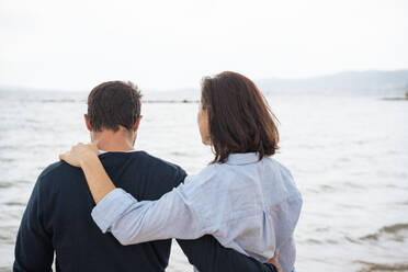 Couple standing together in front of sea - JOSEF20058