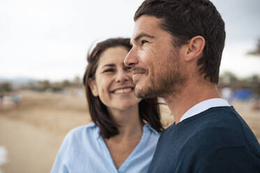 Happy man and woman at beach in front of sky - JOSEF20063