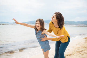 Fröhliche Mutter spielt mit ihrer Tochter am Strand - JOSEF20080