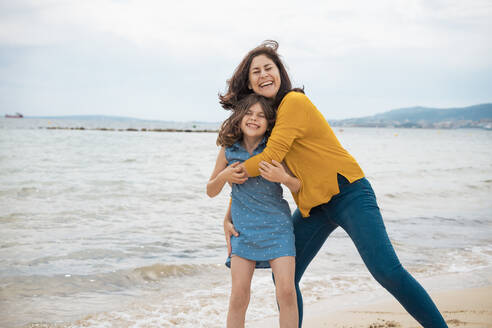 Happy mother and daughter enjoying vacations at beach - JOSEF20117