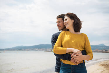 Happy loving couple standing together at beach on sunny day - JOSEF20130