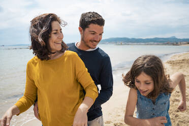 Glückliches Mädchen genießt mit Vater und Mutter am Strand - JOSEF20131