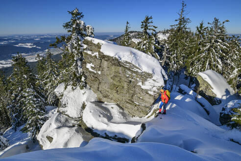 Frau beim Wandern auf einem schneebedeckten Berg - ANSF00453