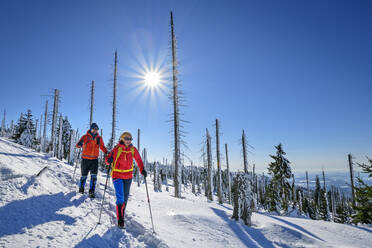 Couple skiing on snowcapped landscape on sunny day - ANSF00457