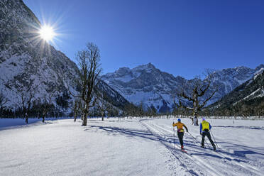 Pärchen beim Skifahren in schneebedeckter Landschaft Richtung Karwendelgebirge - ANSF00464