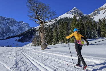 Frau beim Skifahren in verschneiter Landschaft Richtung Karwendelgebirge - ANSF00465