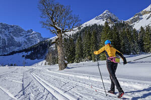 Frau beim Skifahren in verschneiter Landschaft Richtung Karwendelgebirge - ANSF00465