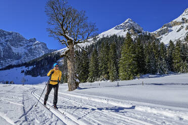 Frau beim Skifahren in verschneiter Landschaft am Karwendelgebirge - ANSF00466