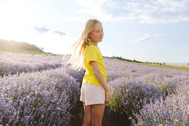 Kontemplatives Mädchen in einem Lavendelfeld unter freiem Himmel - SIF00716