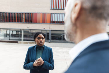 Young businesswoman having discussion with businessman in office park - JOSEF20159