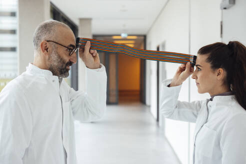 Scientists pretending to connect with multicolored computer cable - JOSEF20182