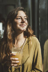 Smiling young woman with glass of juice - JOSEF20265