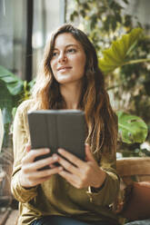 Thoughtful woman holding tablet PC in cafe - JOSEF20284