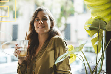 Smiling woman with glass of juice in cafe - JOSEF20290