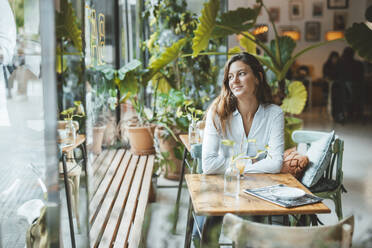 Contemplative young woman sitting in cafe - JOSEF20305