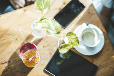 Tablet PC and smart phone with juice on table in cafe - JOSEF20325