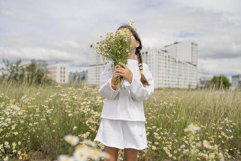 Girl hiding face with bunch of daisy flowers - LESF00389