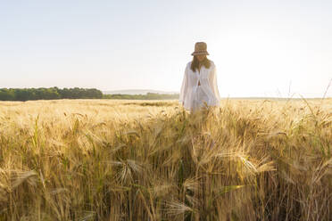 Frau mit Hut inmitten eines Weizenfeldes - AAZF00791