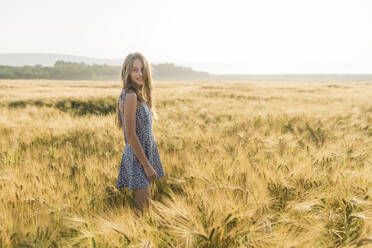 Smiling girl standing amidst crop in wheat field - AAZF00800